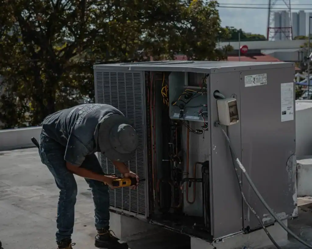 Technician checking filter condition and airflow during AC maintenance in West Melbourne.